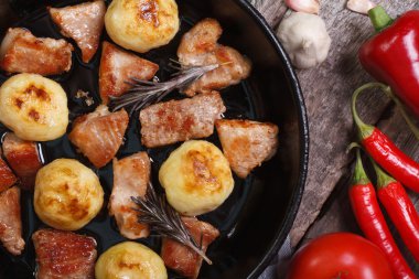 yeni patates ve bir tavada kavrulmuş domuz. Masanın üzerinde sebze.