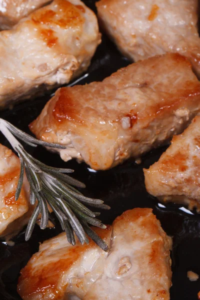 Potongan daging babi goreng dalam wajan dengan rosemary vertikal — Stok Foto