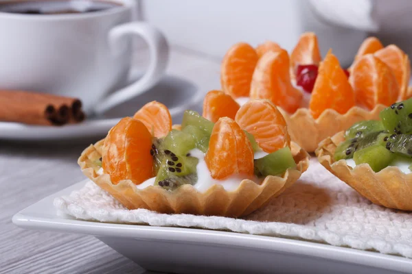 Fruit tartlets with kiwi and tangerine and coffee — Stock Photo, Image