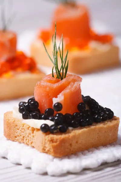 Canapés com caviar de esturjão preto, salmão defumado e endro — Fotografia de Stock