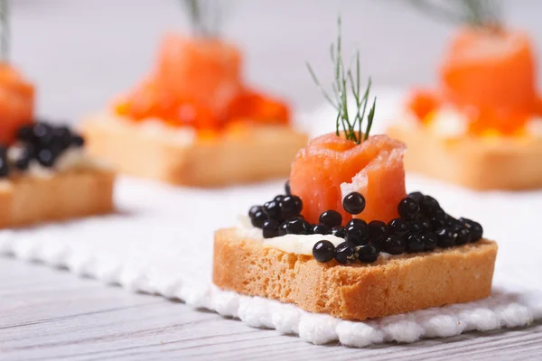 Canapés com caviar de esturjão preto, salmão e endro. macro . — Fotografia de Stock