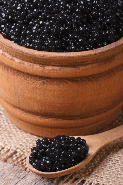 Caviar de esturjão preto em uma colher de madeira macro — Fotografia de Stock