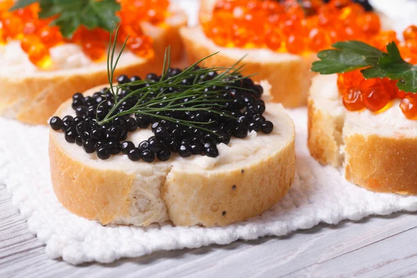 Sanduíches com caviar preto e vermelho na mesa — Fotografia de Stock