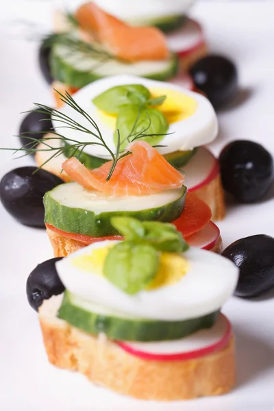 用煮熟的鸡蛋、 蔬菜和鲑鱼的各种烤面包片 — 图库照片