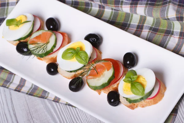 Sandwiches with eggs, smoked salmon and fresh vegetables — Stock Photo, Image