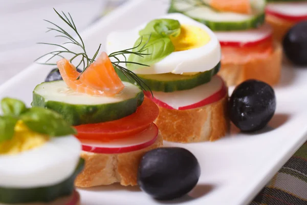 Various banquet canape with salmon, eggs, vegetables — Stock Photo, Image