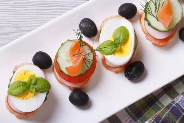 Various banquet canape with salmon, eggs top view — Stock Photo, Image
