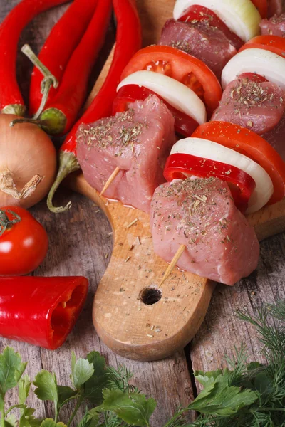 Shashlik crudo con verduras en una tabla de cortar —  Fotos de Stock