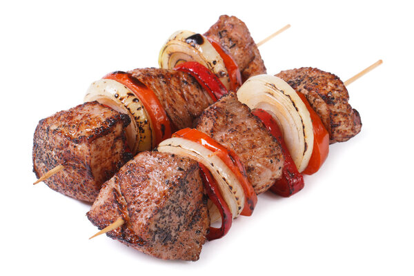 two skewers of meat with vegetables isolated on a white