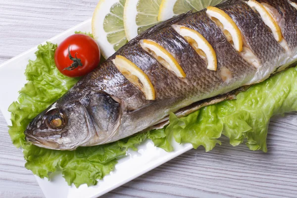 Grilled sea bass with lemon and lettuce top view. horizontal — Stock Photo, Image