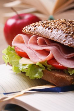 Öğle Yemeği: jambon ve defter üzerinde kırmızı elma ile sandviç