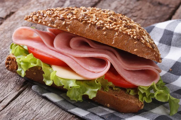 Sandwich met ham, sla en tomaten op een oude tabel — Stockfoto