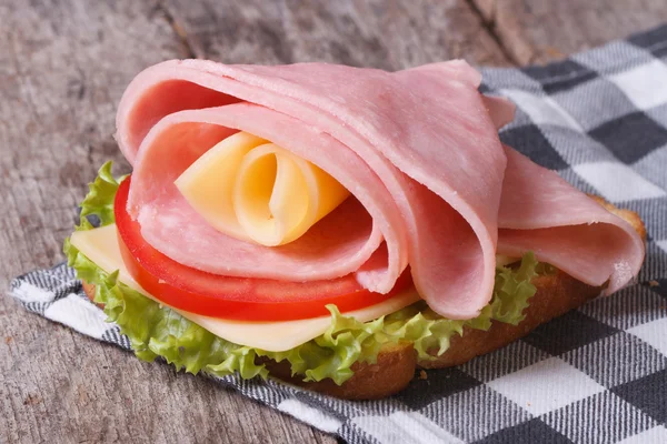 Вкусный сэндвич с ветчиной и сыром на столе — стоковое фото