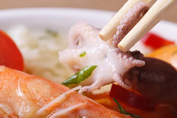 To hold an octopus by means of chopsticks macro — Stock Photo, Image