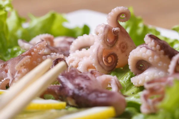 Octopus with lettuce and chopsticks macro — Stock Photo, Image