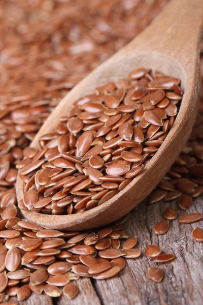 Flax seeds in a wooden spoon macro. Vertical — Stock Photo, Image