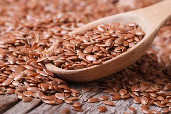 Flax seeds close up on a wooden spoon on a table — Stock Photo, Image