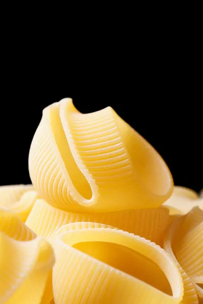 Uncooked Italian macaroni  lumaconi on black background — Stock Photo, Image