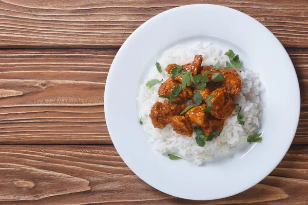 Curry de poulet avec riz et coriandre sur une assiette vue du dessus — Photo