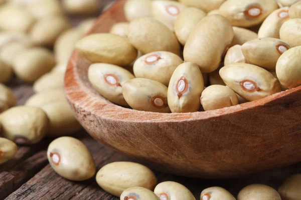 Fagioli gialli pallidi crudi macro a cucchiaio di legno . — Foto Stock