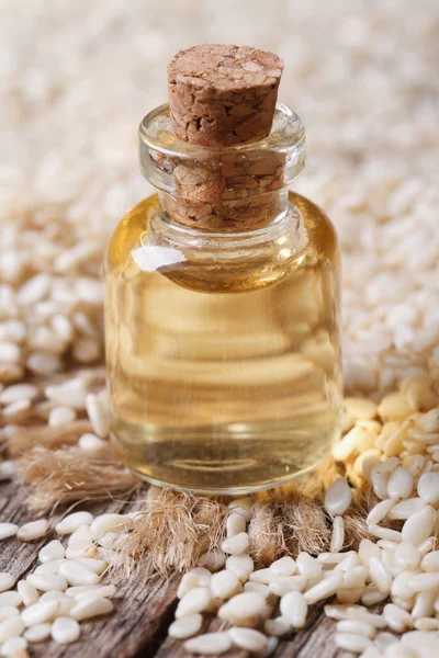 Óleo de semente de gergelim em garrafa de vidro closeup vertical — Fotografia de Stock