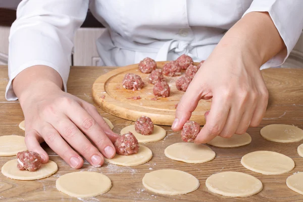 Hands closeup lay out meat balls on  dough rounds — Stock Photo, Image