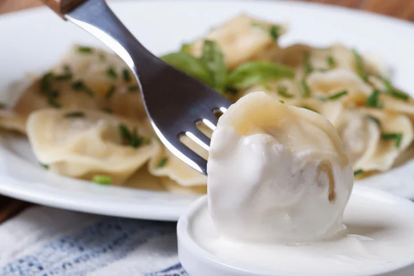 Dumpling på en gaffel i gräddfil. makro — Stockfoto