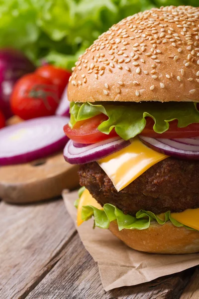 Hamburger on the table against the background of ingredients — Stock Photo, Image