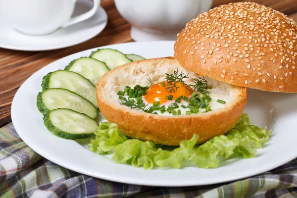 Huevos al horno en un bollo con verduras en un plato blanco — Foto de Stock