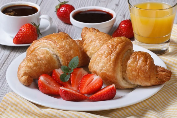 Frukost: croissanter med jordgubbar och kaffe, juice — Stockfoto