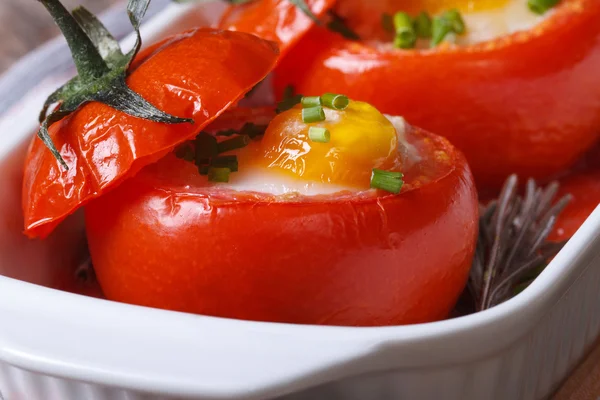 Baked ripe tomato filled with eggs and greens. macro — Stock Photo, Image