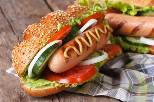 Hot dog in a bun with sesame seeds and grilled sausage — Stock Photo, Image