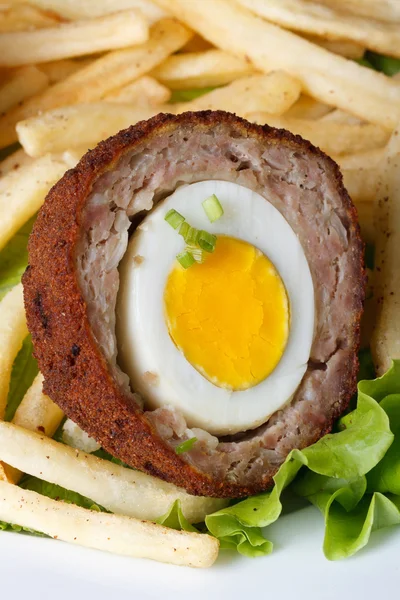 By scotch egg with french fries macro. Vertical — Stock Photo, Image
