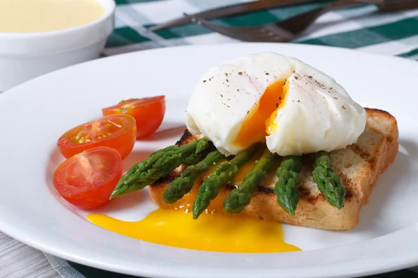 Toast med sparris och pocherat ägg på en vit platta. — Stockfoto