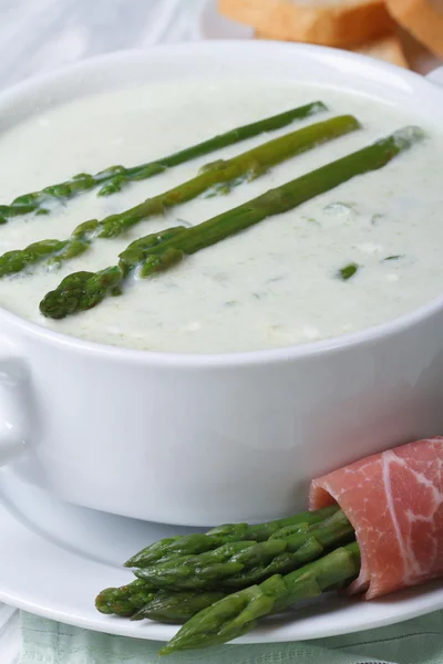 Soupe d'asperges dans un bol blanc macro et croque — Photo