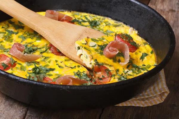 Frittata with tomato, ham and herbs  in the pan with a spatula — Stock Photo, Image
