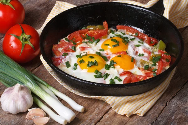 Fried eggs with vegetables on a frying pan — Stock Photo, Image