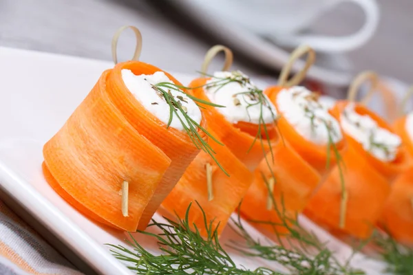 Rollos de zanahorias frescas con queso blando sobre la mesa — Foto de Stock