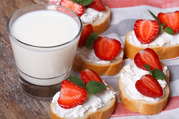 sandwiches with soft cheese and fresh strawberries and milk