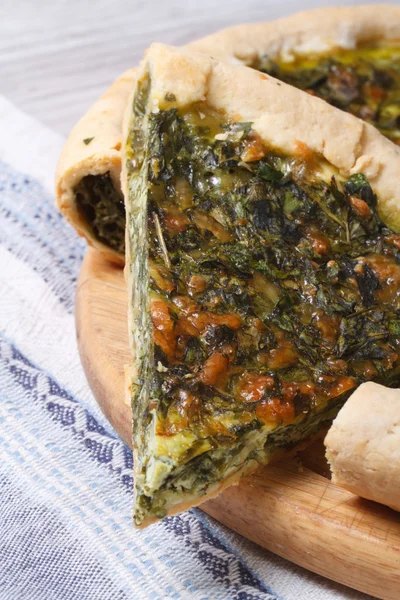 Pedaço de torta com espinafre verde e queijo fechar vertical — Fotografia de Stock