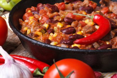 Meksikalı chili con carne ahşap arka plan üzerinde bir tavada 