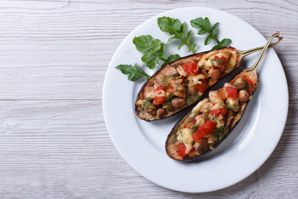 Half baked eggplants with meat, cheese and tomatoes 