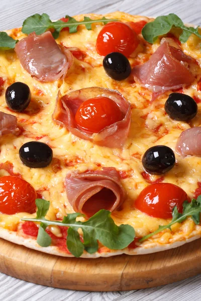 Pizza with prosciutto ham, tomatoes, black olives and arugula — Stock Photo, Image