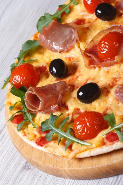 Pizza se šunkou, rajčaty, sýrem, olivami a rukolou — Stock fotografie