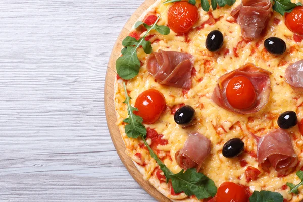 Пицца с ветчиной и рукколой вблизи горизонтального вида сверху — стоковое фото