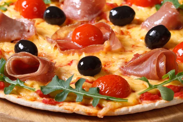 Italian pizza with prosciutto ham and arugula macro — Stock Photo, Image