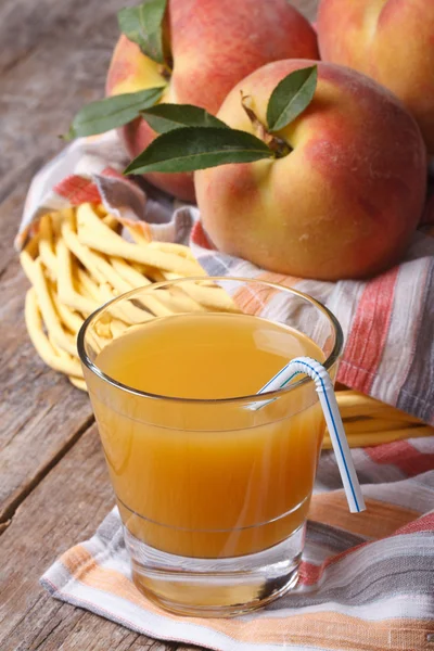 Fragrant peach juice and fruit in a basket — Stock Photo, Image