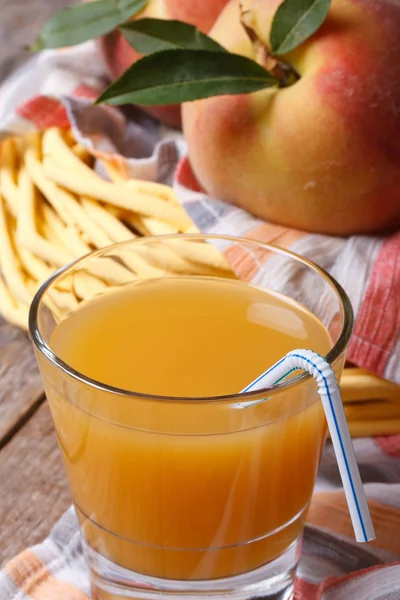 Peach juice in glass closeup on a background of fruit — Stock Photo, Image