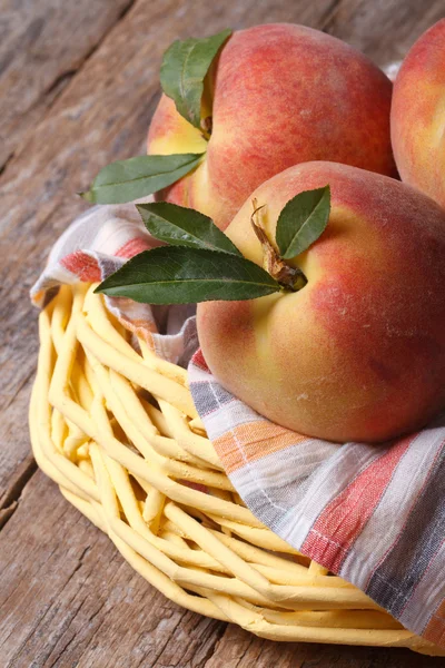 Fresh juicy peaches in a basket on the table closeup — Stock Photo, Image