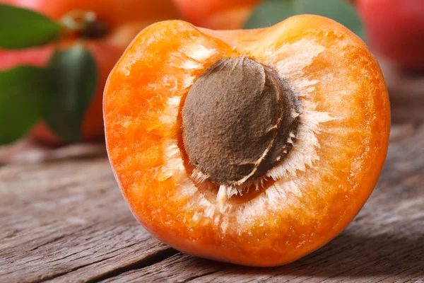 Half of ripe apricots with bone macro on a wooden — Stock Photo, Image